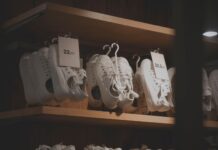 Jak czyścić białe sneakersy, żeby wyglądały jak nowe: domowe sposoby i sprawdzone preparaty Białe sneakersy na drewnianych półkach w nowoczesnym sklepie