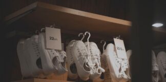 Białe sneakersy na drewnianych półkach w nowoczesnym sklepie