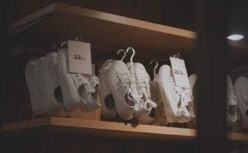 Jak czyścić białe sneakersy, żeby wyglądały jak nowe: domowe sposoby i sprawdzone preparaty Białe sneakersy na drewnianych półkach w nowoczesnym sklepie