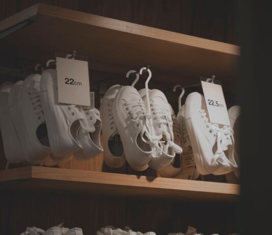 Białe sneakersy na drewnianych półkach w nowoczesnym sklepie