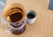 Kawa speciality dla początkujących: jak zacząć przygodę z lepszym ziarnem i nie zwariować Drip z kawą w filtrze obok ceramicznego kubka na drewnianym stole