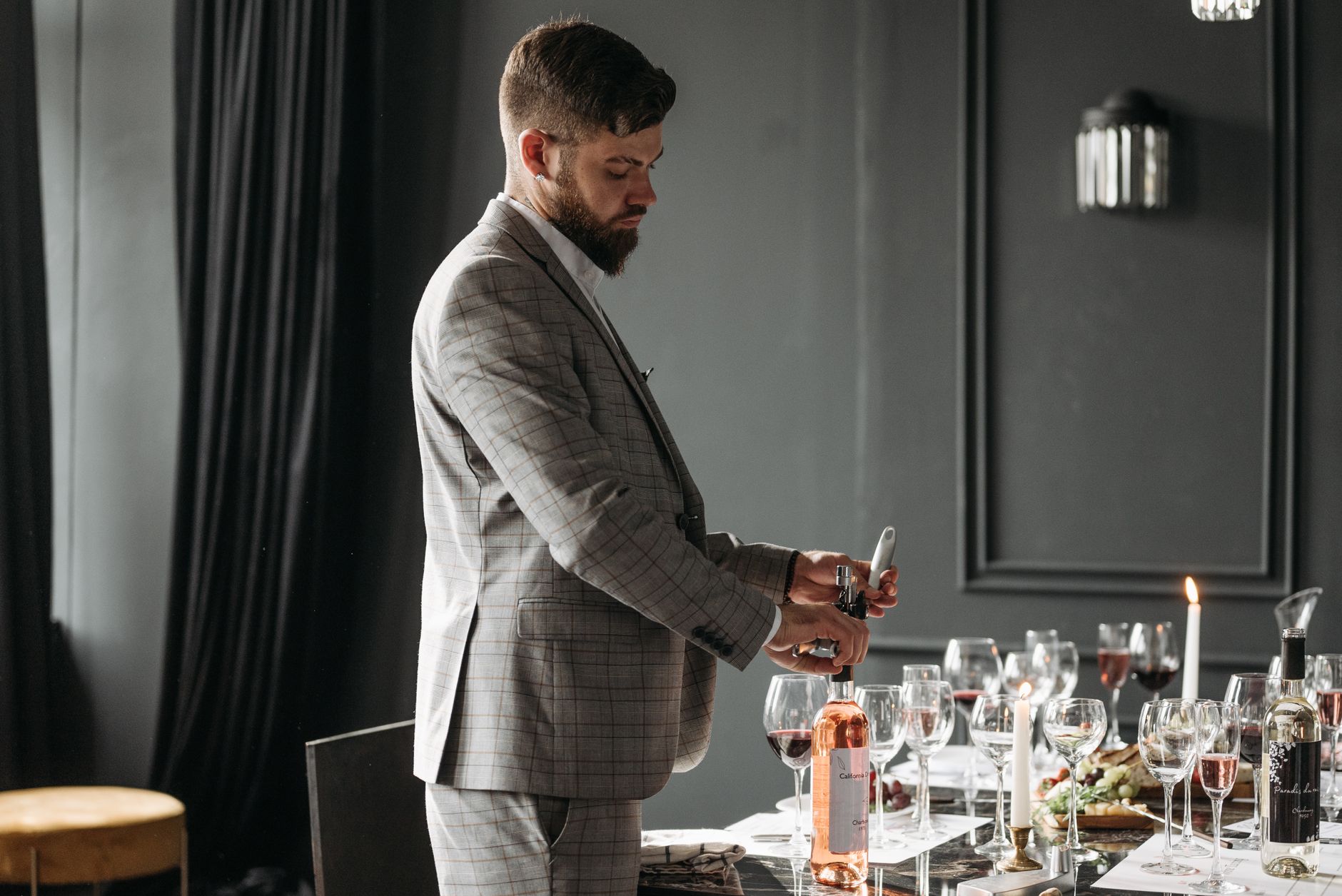 Sommelier otwierający butelki wina na formalnej degustacji wewnątrz